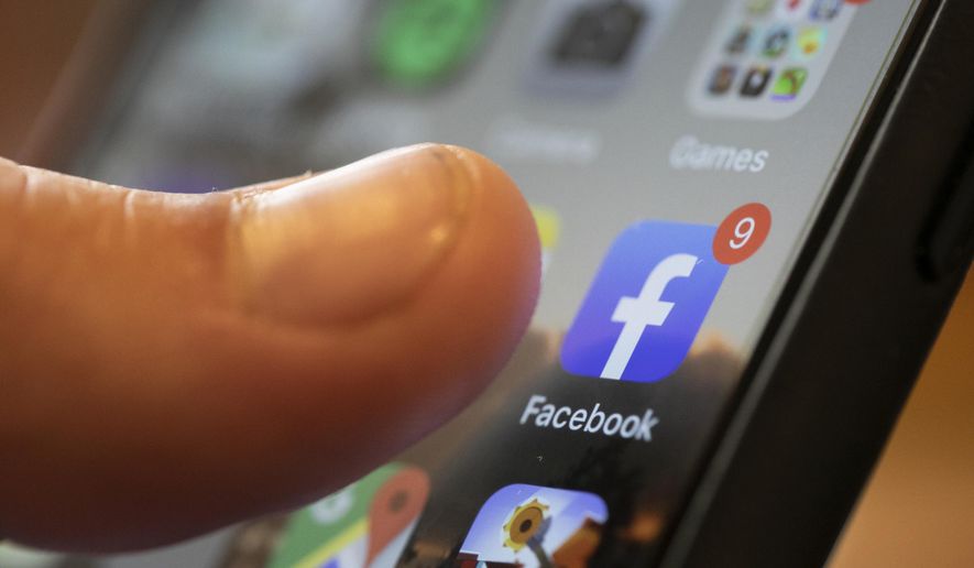 In this Aug. 11, 2019, file photo, an iPhone displays the Facebook app in New Orleans. (AP Photo/Jenny Kane, File)