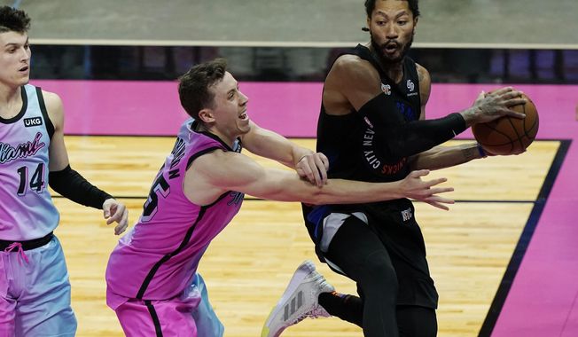 New York Knicks guard Derrick Rose looks to pass the ball as Miami Heat guard Duncan Robinson (55) defends during the first half of an NBA basketball game, Tuesday, Feb. 9, 2021, in Miami. (AP Photo/Marta Lavandier)