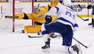 Nashville Predators goaltender Juuse Saros (74) reaches for a shot by Tampa Bay Lightning center Steven Stamkos (91) but can&#x27;t stop the puck as Stamkos scores in the third period of an NHL hockey game Tuesday, Feb. 9, 2021, in Nashville, Tenn. (AP Photo/Mark Humphrey)