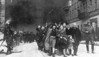 FILE - In this 1943 file photo, a group of Polish Jews are led away for deportation by German SS soldiers during the destruction of the Warsaw Ghetto by German troops after an uprising in the Jewish quarter. A Warsaw court is scheduled to deliver a verdict Tuesday, Feb. 9, 2021 in a closely watched libel case in which Polish national dignity and the independence of Holocaust research are said to be at stake. (AP Photo, file)