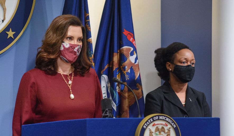 Governor Gretchen Whitmer, left, speaks as Michigan Department of Health and Human Services Chief Medical Executive, Dr. Joneigh Khaldun, listens in Lansing, Mich., Tuesday, Feb. 9, 2021. (Michigan Office of the Governor via AP)