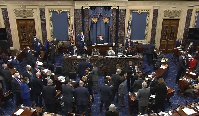 In this image from video, senators gather around Senate Majority Leader Chuck Schumer of N.Y., and House impeachment manager Rep. Jamie Raskin, D-Md., bottom left, after Sen. Mike Lee, R-Utah, made an objection to evidence presented by House impeachment managers during the second impeachment trial of former President Donald Trump in the Senate at the U.S. Capitol in Washington, Wednesday, Feb. 10, 2021. (Senate Television via AP)