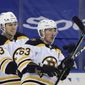 Boston Bruins&#39; Charlie McAvoy (73) and Brad Marchand (63) celebrate Marchand&#39;s overtime winning goal against the New York Rangers in an NHL hockey game Wednesday, Feb. 10, 2021, in New York. (Bruce Bennett/Pool Photo via AP)