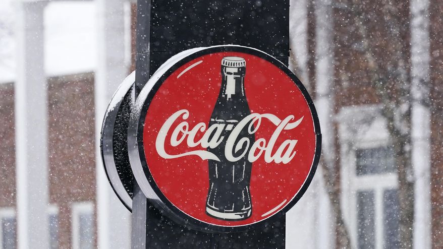 A Coca-Cola sign hangs outside a Coca-Cola distributor, Tuesday, Feb. 9, 2021, in Bedford, Ohio. The resurgent coronavirus slowed Coca-Cola’s recovery in the fourth quarter, and the company said the slump has continued through the first months of this year. (AP Photo/Tony Dejak)