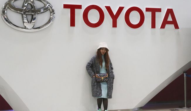 A woman stands at Toyota gallery in Tokyo on Jan. 15, 2020. Toyota reported a 50% jump in its October to December profit Wednesday, Feb. 10, 2021, underlining a solid recovery at the Japanese automaker from the damage of the coronavirus pandemic. (AP Photo/Koji Sasahara)