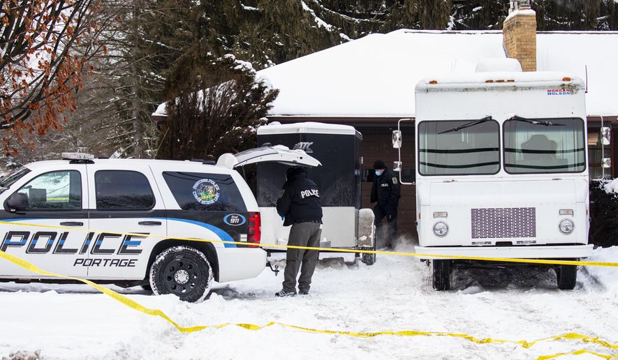 Portage police investigate a missing persons case in Portage, Mich. on Tuesday, Feb. 9, 2021. Police checking on a Kalamazoo-area man who didn’t report to work online put yellow tape around the property. Officers also brought shovels to the backyard. Gary and Laura Johnson, both in their mid-60s, were not at their Portage home, but officers found “signs of violence.” Public Safety Director Nick Armold says there's no “rational explanation” for their disappearance. (Joel Bissell/MLive.com/Kalamazoo Gazette via AP)