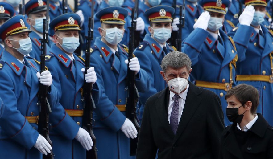 Czech Prime Minister Andrej Babis, centre, reviews the honor guard during a welcome ceremony with his Serbian counterpart Ana Brnabic, right, before their official talks at the Serbia Palace in Belgrade, Serbia, Wednesday, Feb. 10, 2021. Babis is on a one-day official visit to Serbia. (AP Photo/Darko Vojinovic)