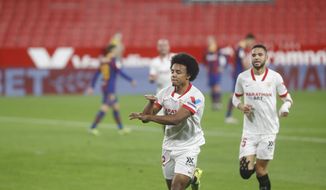 Sevilla&#39;s Jules Kounde celebrates after scoring his side&#39;s first goal during a Spanish Copa del Rey semifinal soccer match between Sevilla and FC Barcelona at Ramon Sanchez Pizjuan stadium in Seville , Spain, Wednesday, Feb. 10, 2021. (AP Photo/Angel Fernandez)