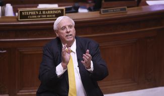 West Virginia Governor Jim Justice applauds the West Virginia Supreme Court Justices during the State of the State Address in the House Chambers of the West Virginia State Capitol Building in Charleston, W.Va., on Wednesday, Feb. 10, 2021. (AP Photo/Chris Jackson)