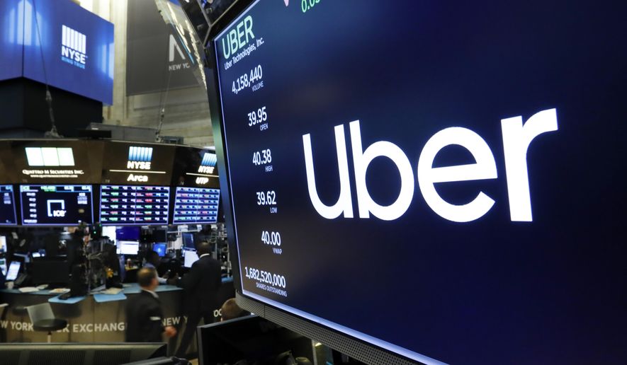 The logo for Uber, the ride-hailing service, appears above a trading post on the floor of the New York Stock Exchange, Thursday, May 30, 2019. (AP Photo/Richard Drew, File)