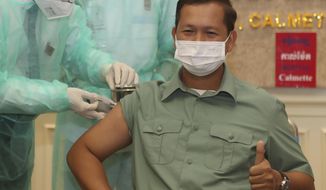 Cambodia&#39;s Lt. Gen. Hun Manet, a son of Prime Minister Hun Sen, thumbs up as he receives a shot of the COVID-19 vaccine at Calmette hospital in Phnom Penh, Cambodia, Wednesday, Feb. 10, 2021. Cambodia began its inoculation campaign against the COVID-19 virus with vaccines donated from China, the country’s closest ally.  (AP Photo/Heng Sinith)