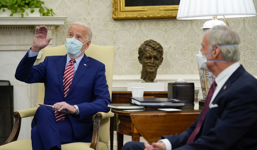 Sen. Tom Carper, D-Del., right, listens as President Joe Biden speaks during a meeting with lawmakers on investments in infrastructure, in the Oval Office of the White House, Thursday, Feb. 11, 2021, in Washington. (AP Photo/Evan Vucci)