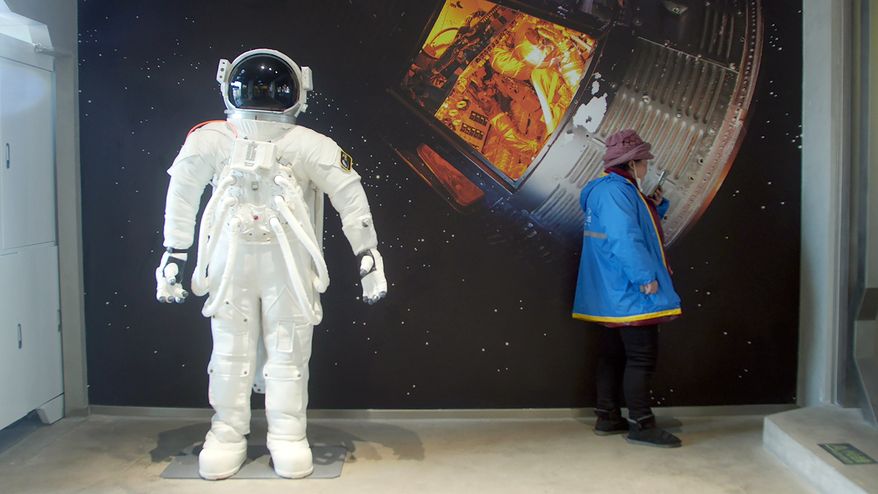 A delivery driver waits for an order at a space-themed cafe in Beijing, Wednesday, Feb. 10, 2021. China is falling in love with space, inspired by the ruling Communist Party's increasingly ambitious missions over the past two decades to fire humans into orbit and explore the moon and Mars. (AP Photo/Sam McNeil)
