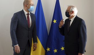European Union foreign policy chief Josep Borrell, right, talks to Ukraine&#39;s Prime Minister Denys Shmyhal as they arrive for an EU-Ukraine Association Council at the European Council headquarters in Brussels, Thursday, Feb. 11, 2021. (Francois Walschaerts, Pool Photo via AP)