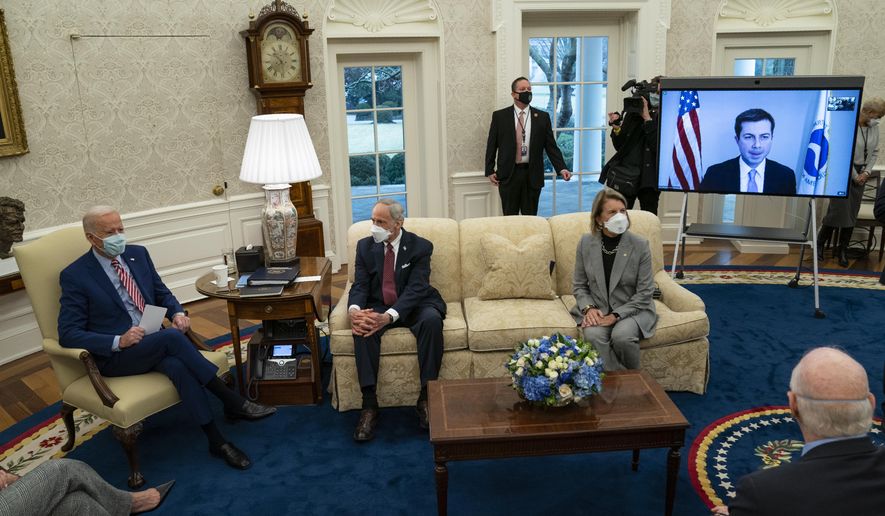President Joe Biden speaks during a meeting with lawmakers on investments in infrastructure, in the Oval Office of the White House, Thursday, Feb. 11, 2021, in Washington. From left, Biden, Sen. Tom Carper, D-Del., Sen. Shelley Moore Capito, R-W.Va., and Transportation Secretary Pete Buttigieg, on screen. (AP Photo/Evan Vucci)