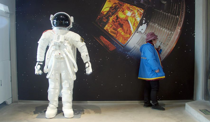 A delivery driver waits for an order at a space-themed cafe in Beijing, Wednesday, Feb. 10, 2021. China is falling in love with space, inspired by the ruling Communist Party's increasingly ambitious missions over the past two decades to fire humans into orbit and explore the moon and Mars. (AP Photo/Sam McNeil)
