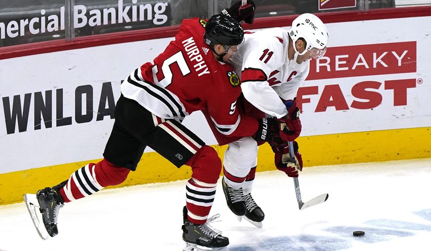 Carolina Hurricanes' Jordan Staal, right, works for the puck against Chicago Blackhawks' Connor Murphy during the second period of an NHL hockey game in Chicago, Thursday, Feb. 4, 2021. (AP Photo/Nam Y. Huh)