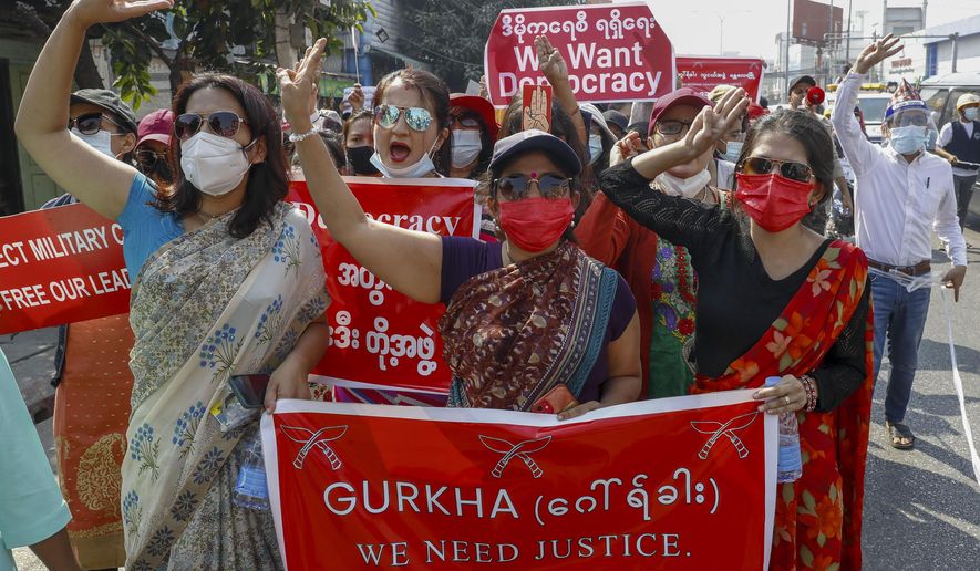 Demonstrators with placards shout slogans against the military coup during a protest in Mandalay, Myanmar on Thursday, Feb. 11, 2021. Large crowds demonstrating against the military takeover in Myanmar again defied a ban on protests Thursday, even after security forces ratcheted up the use of force against them and raided the headquarters of the political party of ousted leader Aung San Suu Kyi a day earlier. (AP Photo)