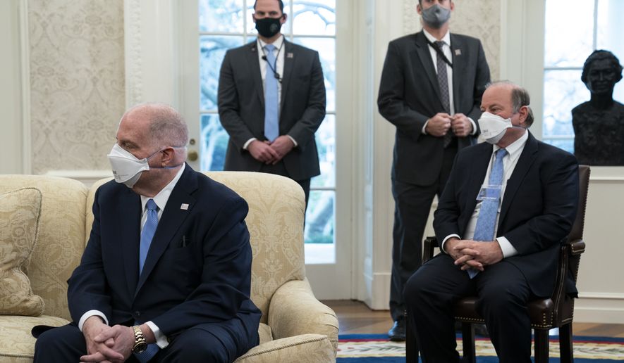 Gov. Larry Hogan, R-Md., left, and Mayor Mike Duggan, D-Detroit, listen as President Joe Biden speaks during a meeting with a bipartisan group of mayors and governors to discuss a coronavirus relief package, in the Oval Office of the White House, Friday, Feb. 12, 2021, in Washington. (AP Photo/Evan Vucci)