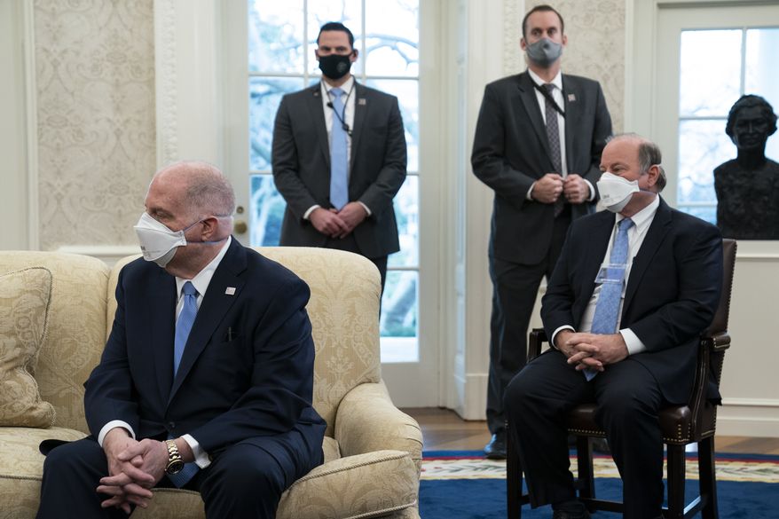 Gov. Larry Hogan, R-Md., left, and Mayor Mike Duggan, D-Detroit, listen as President Joe Biden speaks during a meeting with a bipartisan group of mayors and governors to discuss a coronavirus relief package, in the Oval Office of the White House, Friday, Feb. 12, 2021, in Washington. (AP Photo/Evan Vucci)