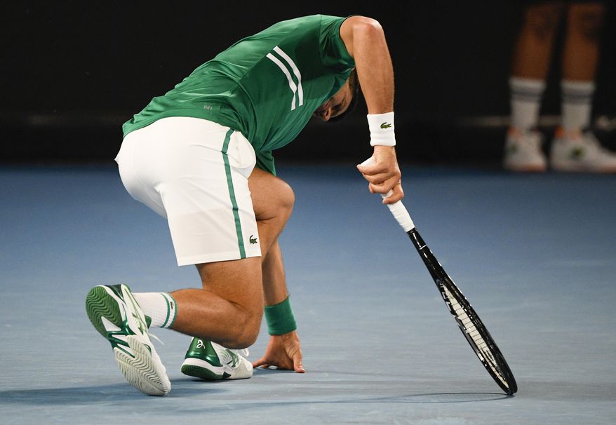 Serbia&#x27;s Novak Djokovic stumbles during his third round match against United States&#x27; Talyor Fritz at the Australian Open tennis championship in Melbourne, Australia, Friday, Feb. 12, 2021.(AP Photo/Andy Brownbill)