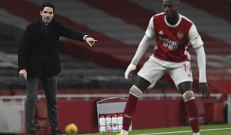 Arsenal&#39;s manager Mikel Arteta, left, gives instructions to his players during the English Premier League soccer match between Arsenal and Manchester United at the Emirates stadium in London, Saturday, Jan. 30, 2021. (Andy Rain/Pool via AP)