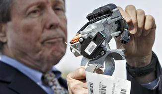 FILE - In this April 1, 2014, file photo, Clarence Ditlow, executive director of the Center for Auto Safety, displays a GM ignition switch similar to those linked to 13 deaths and dozens of crashes of General Motors small cars like the Chevy Cobalt, during a news conference on Capitol Hill in Washington. General Motors Co., has agreed to a $5.75 million settlement with California regarding false statements the company made to investors about problems with its deadly ignition switches, state officials announced Friday, Feb. 12, 2021. The faulty ignition switches led to at least 124 fatalities and 274 injuries nationwide. (AP Photo/J. Scott Applewhite, File)