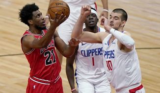 Chicago Bulls forward Thaddeus Young, left, drives to the basket against Los Angeles Clippers guard Reggie Jackson, center, and center Ivica Zubac during the first half of an NBA basketball game in Chicago, Friday, Feb. 12, 2021. (AP Photo/Nam Y. Huh)