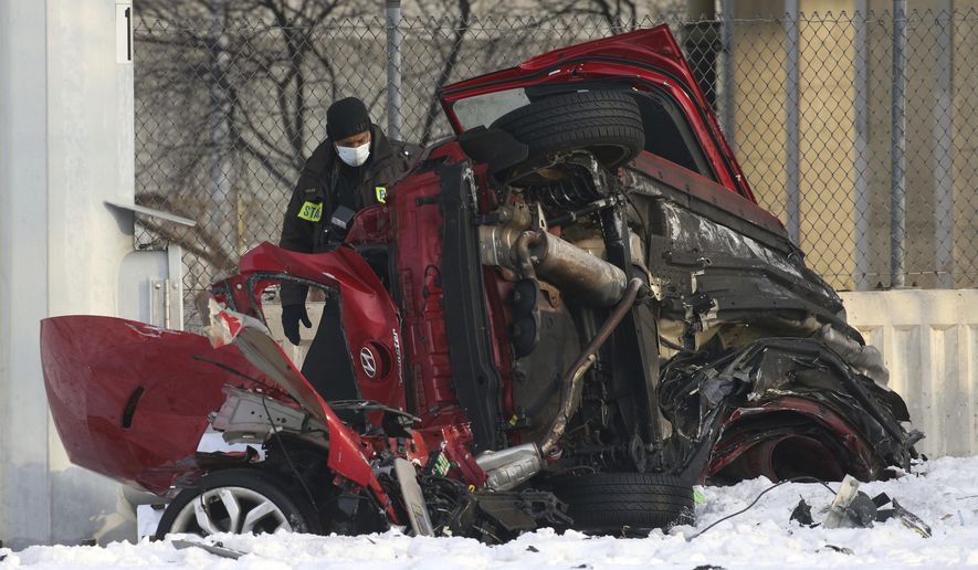 State police officers investigate the scene of a fatal crash Friday, Feb. 12, 2021 in Chicago. Police say some people were killed and others were seriously injured when their vehicle hit a concrete wall along a Chicago expressway and plunged off the highway onto a street 50 feet below. (Antonio Perez /Chicago Tribune via AP)