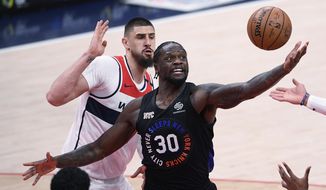 New York Knicks forward Julius Randle (30) reaches for the ball in front of Washington Wizards center Alex Len, back, during the second half of an NBA basketball game Friday, Feb. 12, 2021, in Washington. (AP Photo/Nick Wass)