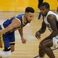 Golden State Warriors guard Stephen Curry, left, dribbles against Orlando Magic forward Gary Clark during the first half of an NBA basketball game in San Francisco, Thursday, Feb. 11, 2021. (AP Photo/Jeff Chiu)