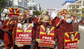 Buddhist monks display pictures of deposed leader Aung San Suu Kyi during a street march against the military coup in Mandalay, Myanmar on Friday, Feb. 12, 2021. Myanmar&#39;s coup leader used the country&#39;s Union Day holiday on Friday to call on people to work with the military if they want democracy, a request likely to be met with derision by protesters who are pushing for the release from detention of their country&#39;s elected leaders. (AP Photo)