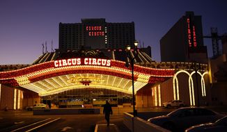 A man walks in front of the Circus Circus hotel and casino in Las Vegas, Feb. 4, 2021. The toll of the coronavirus is reshaping Las Vegas almost a year after the pandemic took hold. The tourist destination known for bright lights, big crowds, indulgent meals and headline shows is a much quieter place these days. (AP Photo/John Locher)