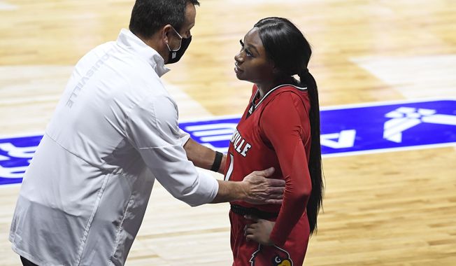 FILE - In this Dec. 4, 2020, file photo, Louisville head coach Jeff Walz, left, speaks with Louisville&#x27;s Dana Evans during the second half of an NCAA college basketball game against DePaul in Uncasville, Conn. Louisville coach Jeff Walz first heard his 5-year-old daughter sing the national anthem while she was in the playroom this week. He was blown away. So was his team after it heard a recorded rendition of Lucy singing “The Star-Spangled Banner” on Thursday night before the Senior Night game against Georgia Tech. (AP Photo/Jessica Hill, File)