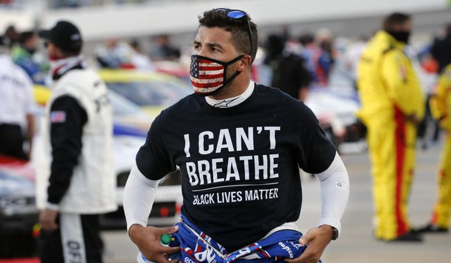 FILE - In this June 10, 2020, file photo, driver Bubba Wallace, wearing an &amp;quot;I Can&#x27;t Breathe&amp;quot; T-shirt waits for the start of a NASCAR Cup Series auto race in Martinsville, Va. A predominantly white sport with deep Southern roots and a longtime embrace of Confederate symbols, NASCAR was forced last summer to face its own checkered racial history during the country’s social unrest. (AP Photo/Steve Helber, File)