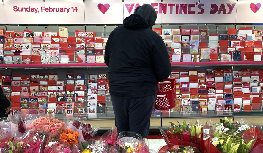 A shopper at a Chicago area store looks over Valentine's Day cards Saturday, Feb. 13, 2021. (AP Photo/Charles Rex Arbogast)