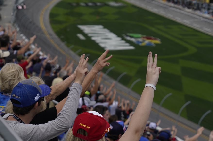 Fans hold up three fingers during a lap three tribute honoring the late Dale Earnhardt, Sr., during the NASCAR Daytona 500 auto race at Daytona International Speedway, Sunday, Feb. 14, 2021, in Daytona Beach, Fla. Dale Earnhardt, Sr., the all-time winner at Daytona, was killed in a fatal car crash at the speedway 20-years ago today. (AP Photo/Chris O&#39;Meara) **FILE**