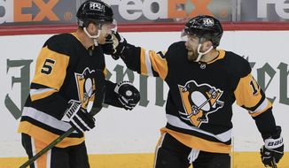 Pittsburgh Penguins&#39; Bryan Rust (17) celebrates Wirth Mike Matheson (5) after getting an assist from him on a goal against the Washington Capitals during the first period of an NHL hockey game, Sunday, Feb. 14, 2021, in Pittsburgh. (AP Photo/Keith Srakocic)
