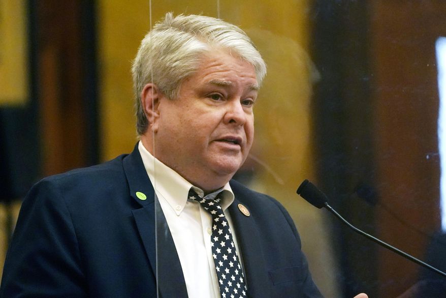 Rep. Steve Hopkins, R-Southaven, stands behind a clear safety barrier that surrounds the speaker's well as he presents a bill for consideration the Capitol in Jackson, Miss., Thursday, Feb. 4, 2021. Legislators continue to debate the long lists of bills that survived the first big deadline of the session. (AP Photo/Rogelio V. Solis)