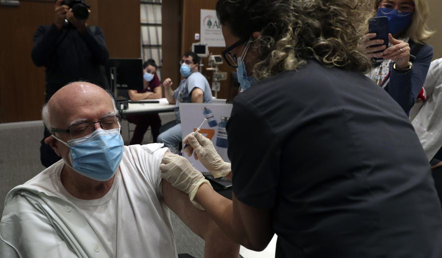A healthcare worker receives Pfizer-BioNTech COVID-19 vaccine during a nationwide vaccination program at the American University Medical Center in Beirut, Lebanon, Sunday, Feb. 14, 2021. (AP Photo/Bilal Hussein)