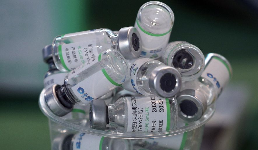 Empty vials of China&#x27;s Sinopharm vaccine sit in a cup during a priority COVID-19 vaccination campaign of health workers at a public hospital in Lima, Peru, Wednesday, Feb. 10, 2021. Peru received its first shipment of COVID-19 vaccines on Sunday night. (AP Photo/Martin Mejia)