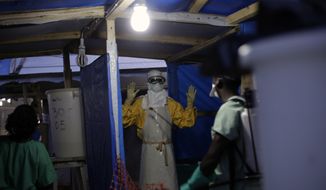 In this Nov. 20, 2014 file photo, an MSF Ebola heath worker is sprayed as he leaves the contaminated zone at the Ebola treatment centre in Gueckedou, Guinea. Guinea has officially declared an Ebola epidemic Monday Feb. 15, 2021, after at least three people have died and others have been infected in the West African nation. (AP Photo/Jerome Delay-File)  **FILE**
