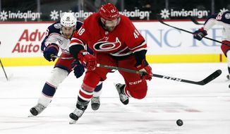 Carolina Hurricanes&#x27; Jordan Martinook (48) skates away from Columbus Blue Jackets&#x27; Michael Del Zotto (15) with the puck during the second period of an NHL hockey game in Raleigh, N.C., Monday, Feb. 15, 2021. (AP Photo/Karl B DeBlaker)