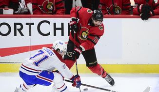 Ottawa Senators&#39; Alex Galchenyuk (17) slaps the puck away from Montreal Canadiens center Jake Evans (71) during the second period of an NHL hockey game in Ottawa on Saturday, Feb. 6, 2021. (Sean Kilpatrick/The Canadian Press via AP)