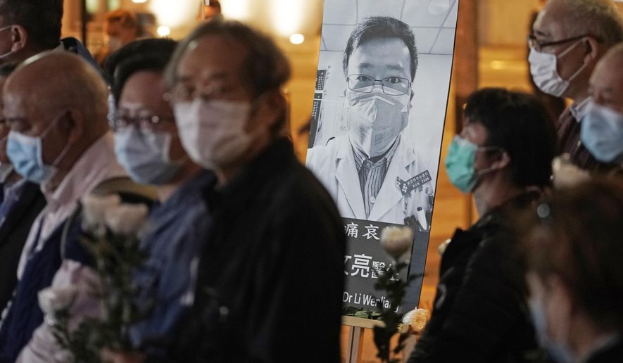 In this Feb. 7, 2020, photo, people wearing masks attend a vigil for Chinese doctor Li Wenliang, in Hong Kong. The outpouring of grief and rage sparked by Li&#39;s death was an unusual — and for the Chinese Communist Party, unsettling — display in China&#39;s tightly monitored civic space. (AP Photo/Kin Cheung) **FILE**