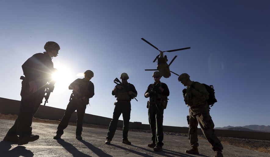 In this Nov. 30, 2017, photo, American soldiers wait on the tarmac in Logar province, Afghanistan. After 20 years of military engagement and billions of dollars spent, NATO and the United States still grapple with the same, seemingly intractable conundrum how to withdraw troops from Afghanistan without abandoning the country to even more mayhem. (AP Photo/Rahmat Gul) **FILE**