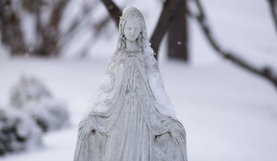 A snow-covered statue of the Virgin Mary is shown on Tuesday, Feb. 16, 2021 in Columbus, Ohio. (Joshua A. Bickel /The Columbus Dispatch via AP)  ** FILE **