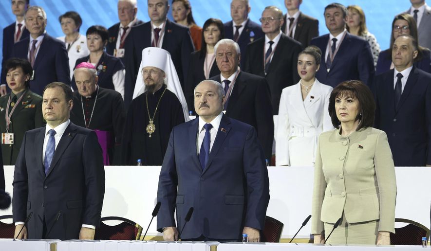 Belarusian Prime Minister Roman Golovchenko, front left, Belarusian President Alexander Lukashenko, centre, Speaker of the Council of the Republic of Belarus Natalya Kochanova, front right, listen to the national anthem at the opening of the All-Belarus People's Assembly in Minsk, Belarus, Thursday, Feb. 11, 2021. Belarus' authoritarian leader has denounced six months of protests against his rule as a foreign-directed "rebellion" and vowed to resist the pressure. Lukashenko convened the gathering Thursday to discuss plans for the country's development. But the opposition has denounced it as an attempt to shore up his rule and soothe public anger with vague promises of reforms. (Maxim Guchek/BelTA Pool Photo via AP)