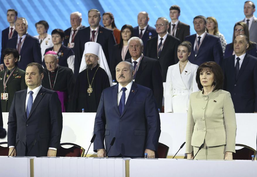 Belarusian Prime Minister Roman Golovchenko, front left, Belarusian President Alexander Lukashenko, centre, Speaker of the Council of the Republic of Belarus Natalya Kochanova, front right, listen to the national anthem at the opening of the All-Belarus People's Assembly in Minsk, Belarus, Thursday, Feb. 11, 2021. Belarus' authoritarian leader has denounced six months of protests against his rule as a foreign-directed "rebellion" and vowed to resist the pressure. Lukashenko convened the gathering Thursday to discuss plans for the country's development. But the opposition has denounced it as an attempt to shore up his rule and soothe public anger with vague promises of reforms. (Maxim Guchek/BelTA Pool Photo via AP)