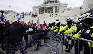 In this Jan. 6, 2021, file photo, rioters try to break through a police barrier at the U.S. Capitol in Washington. (AP Photo/Julio Cortez, File)  **FILE**